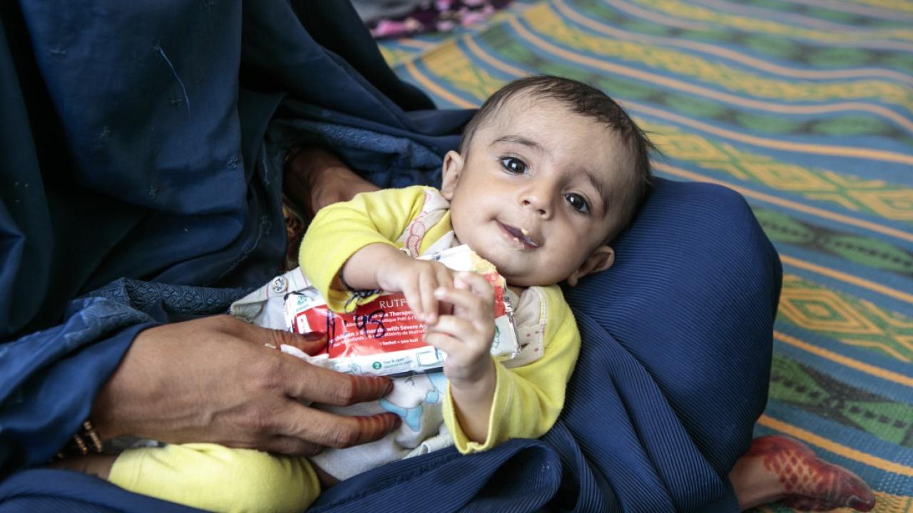 A young boy eats Plumpy'Nut, a peanut paste used to treat malnutrition, at one of Action Against Hunger's nutrition centers in Afghanistan's Helmand province. / Photo by Sandra Calligaro
