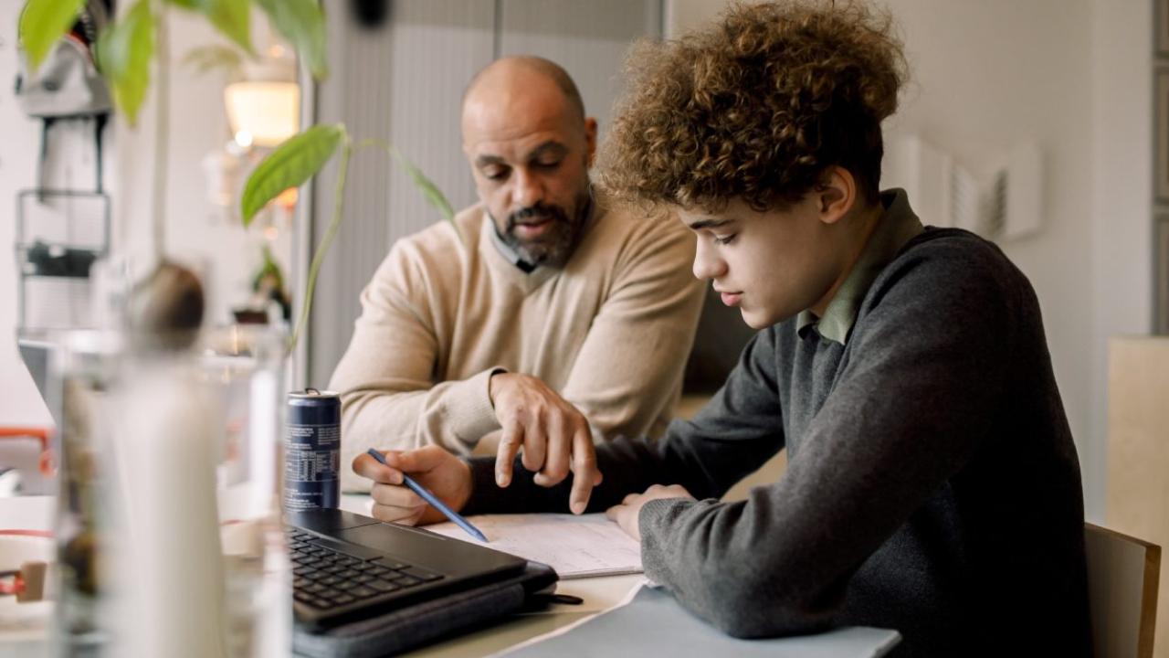 Parent and teenager looking at homework together