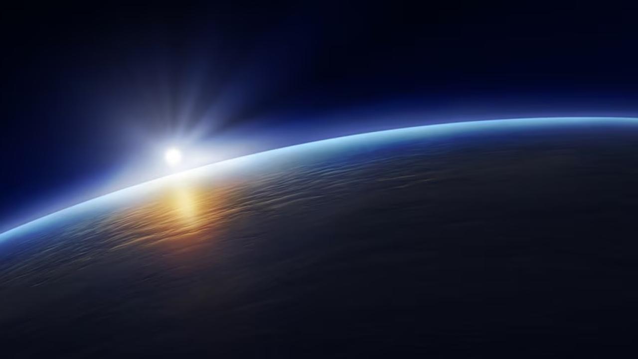 Earth viewed from space, with sun shining behind it