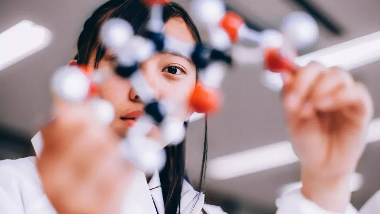 Scientist holding model of a molecule 