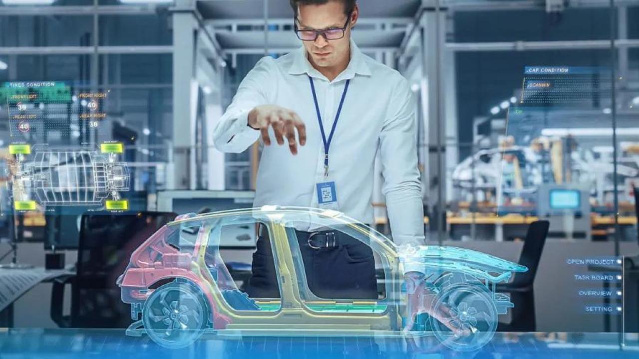 A person holding a hand over a holographic digital sketch of a car.