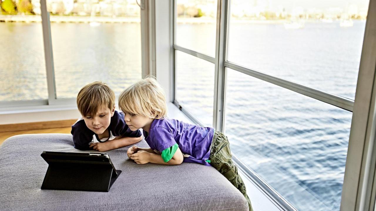 Two children leaning over a laptop computer