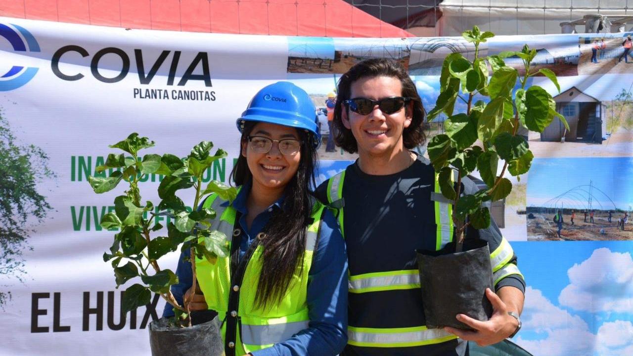 Abel and another posed with tree saplings.