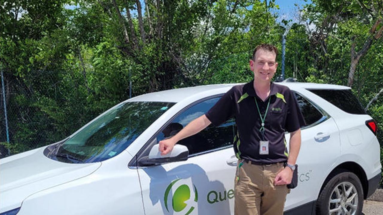 Adam Slough standing by a Quest car outside