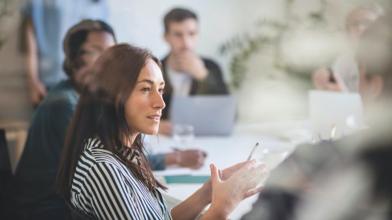 a women speaking during a meeting [Image Credit: Adobe]