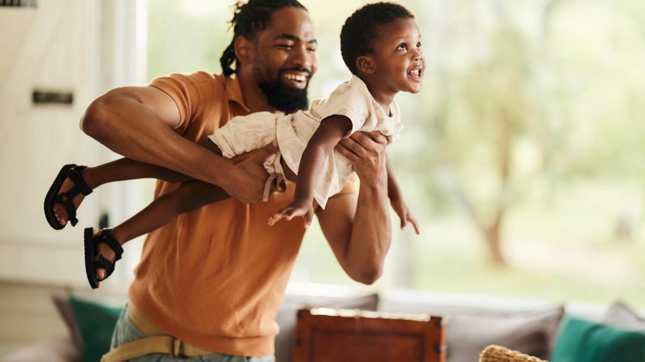 An adult carrying a young child 