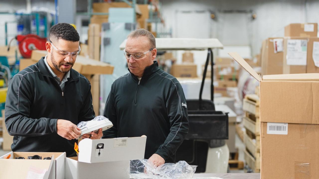 Two people inspecting a product in a delivery.