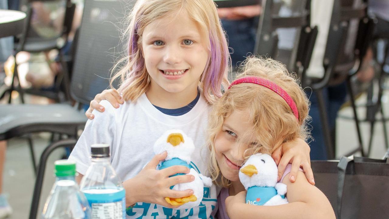 Two children at the Night of Baseball holding Aflac Ducks.