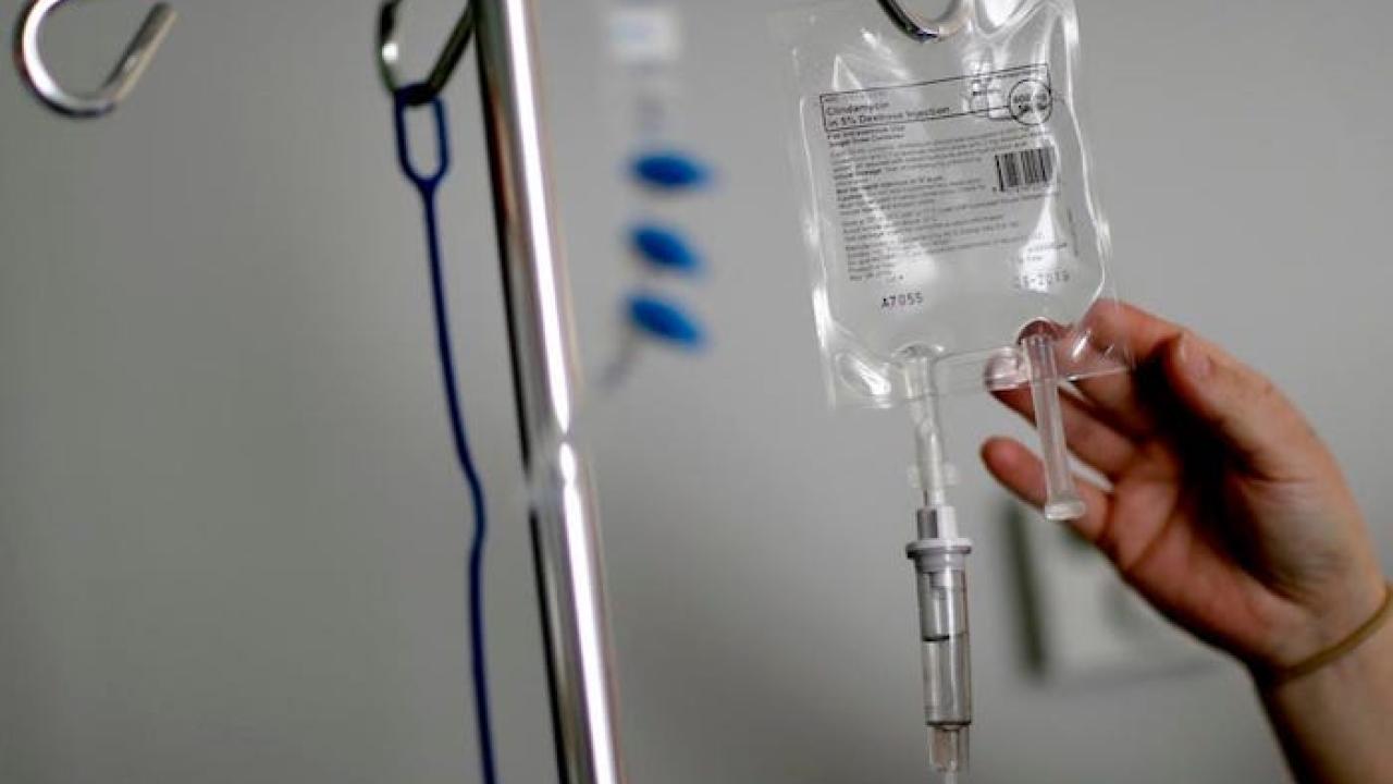 Hanging medical bag with a hand touching the bag.