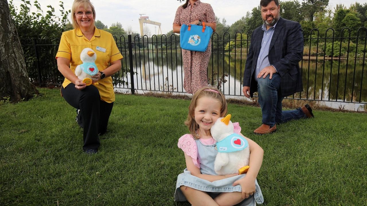 Girl seated holding Aflac duck.