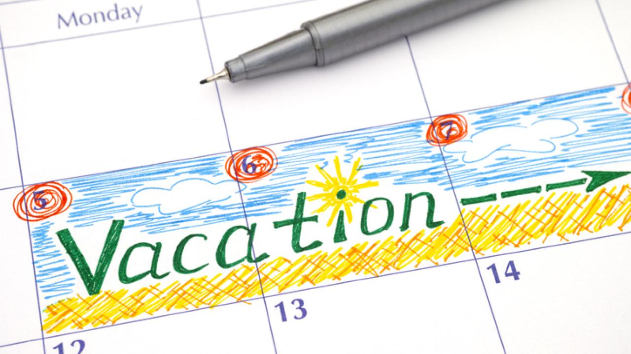 Calendar with pen laying across it and vacation time blocked off.