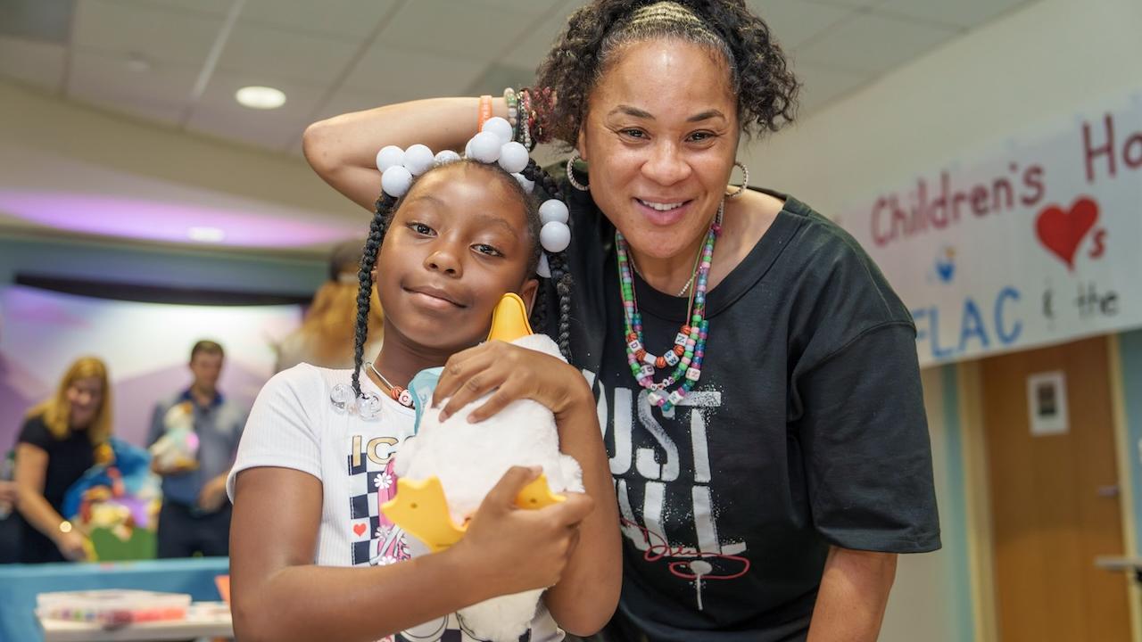 Coach Dawn Staley shown with a patient holding a My Special Aflac Duck.