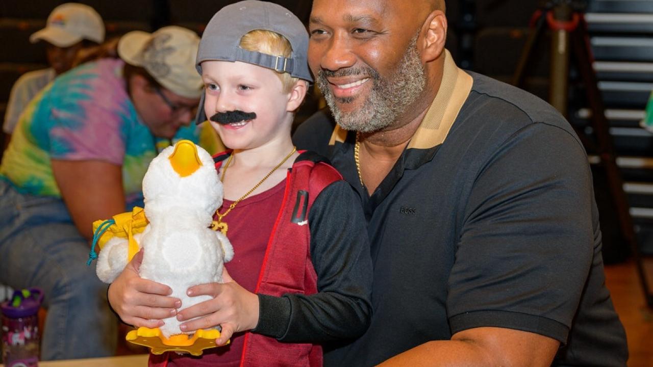 Aflac Duck Delivery. A young child is shown holding the Aflac Duck.