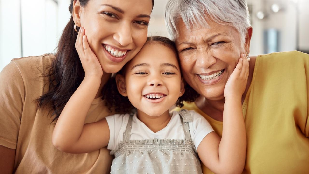 A mom, daughter and grandmother shown in a hug.
