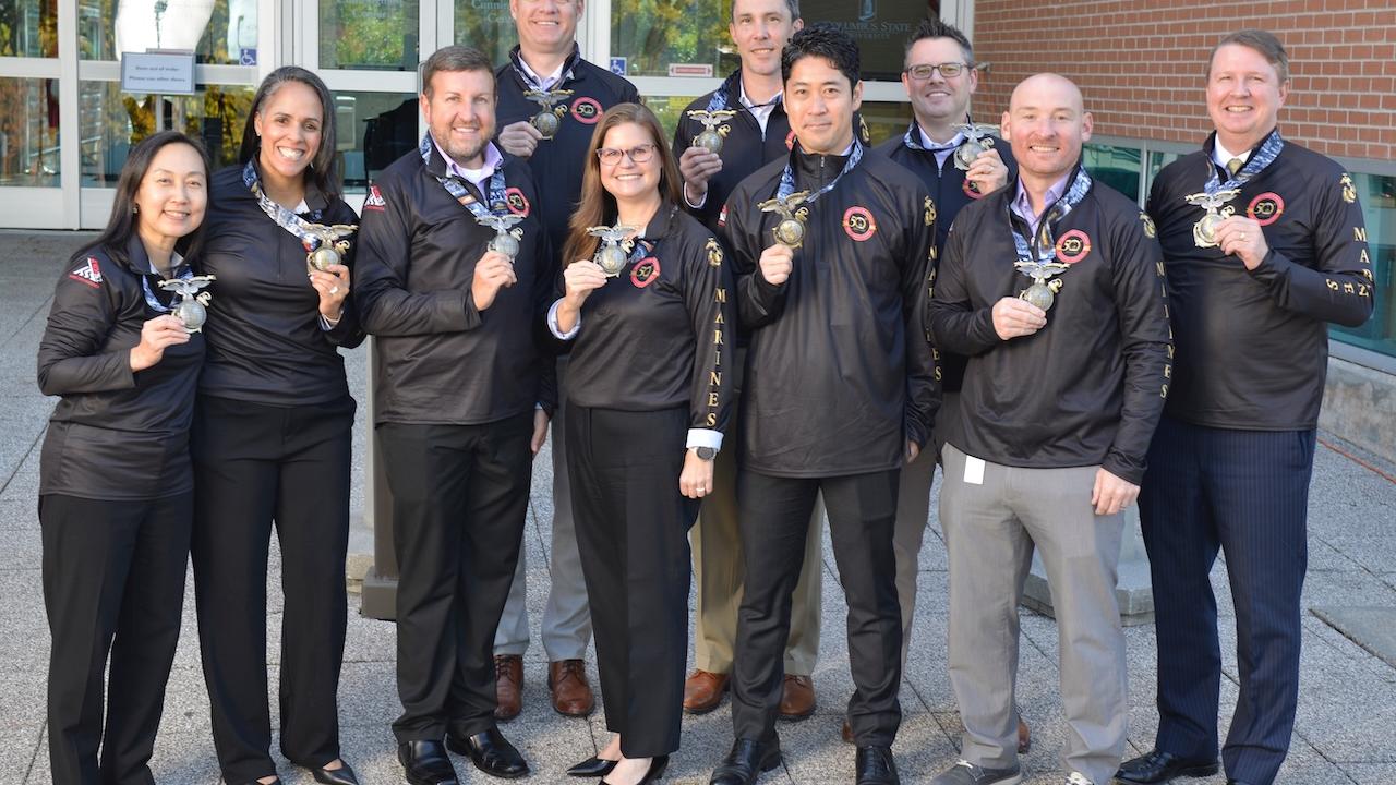 Aflac team members show their medals from the Marine Corps Marathon.