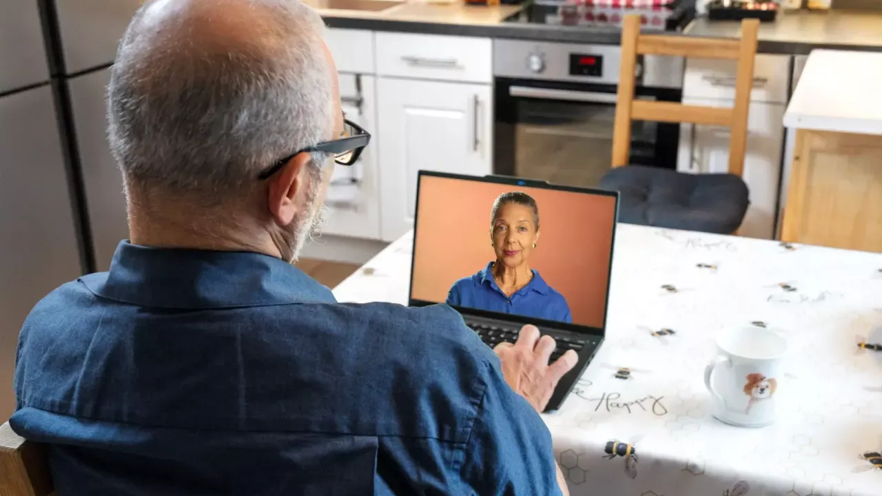 A person sat at a table using a laptop