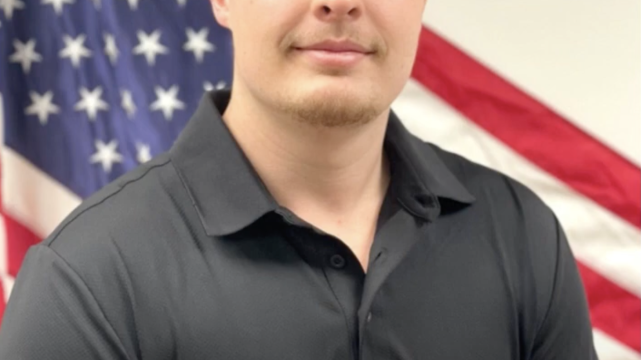 Alex Hutcheson stood in front of the American flag