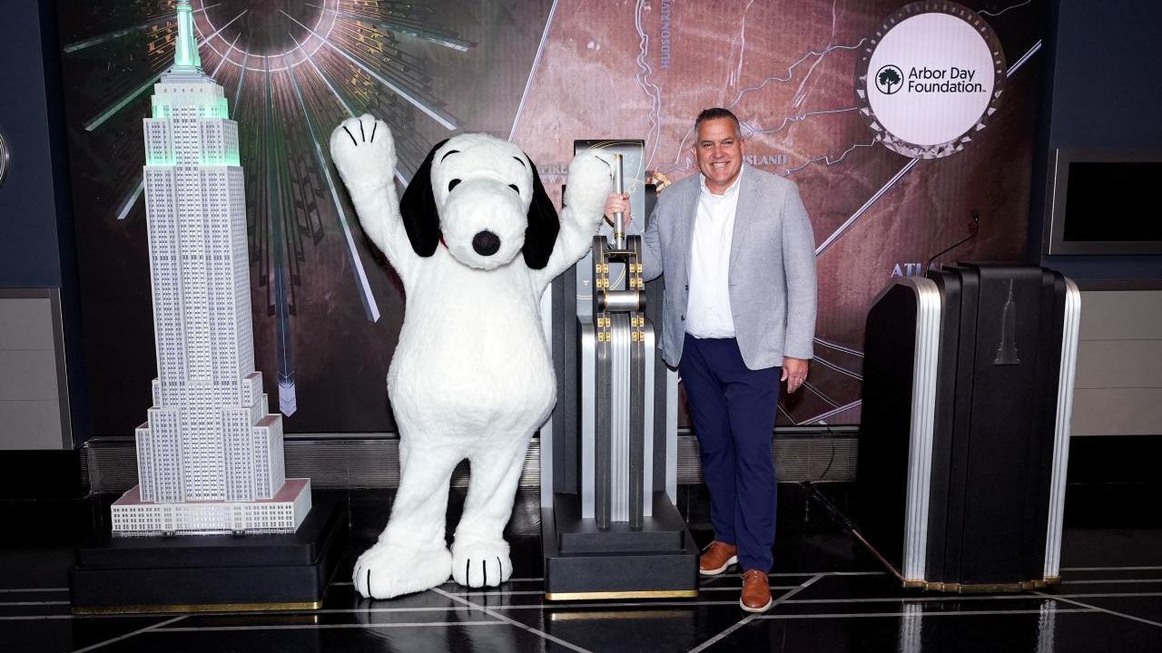 Arbor Day Foundation CEO Dan Lambe and Snoopy flip the switch the light the Empire State Building green.