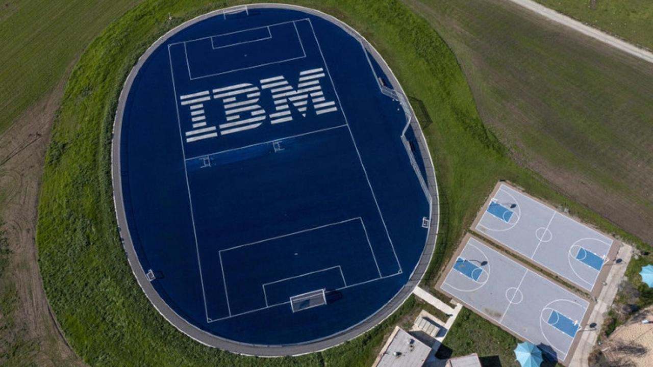 Aerial view of an athletics field, IBM in large print on the blue court.