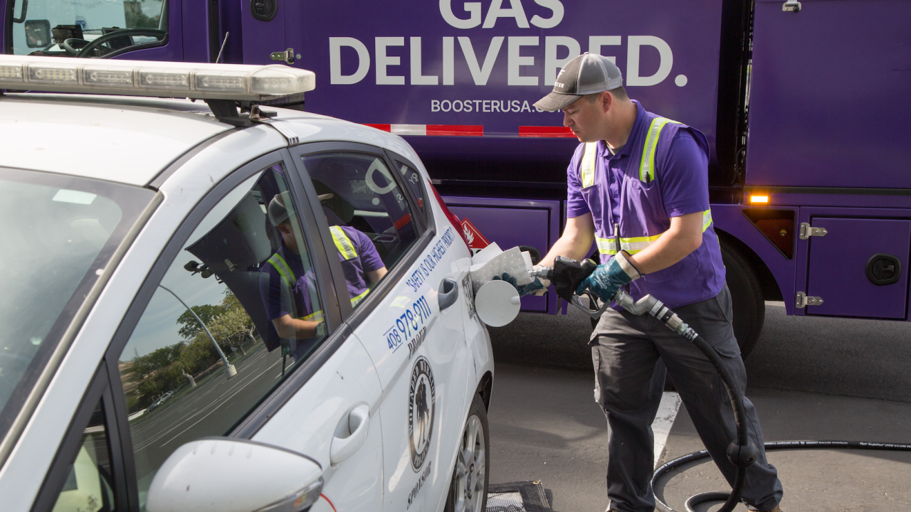 Booster service professional fuels white sedan. 