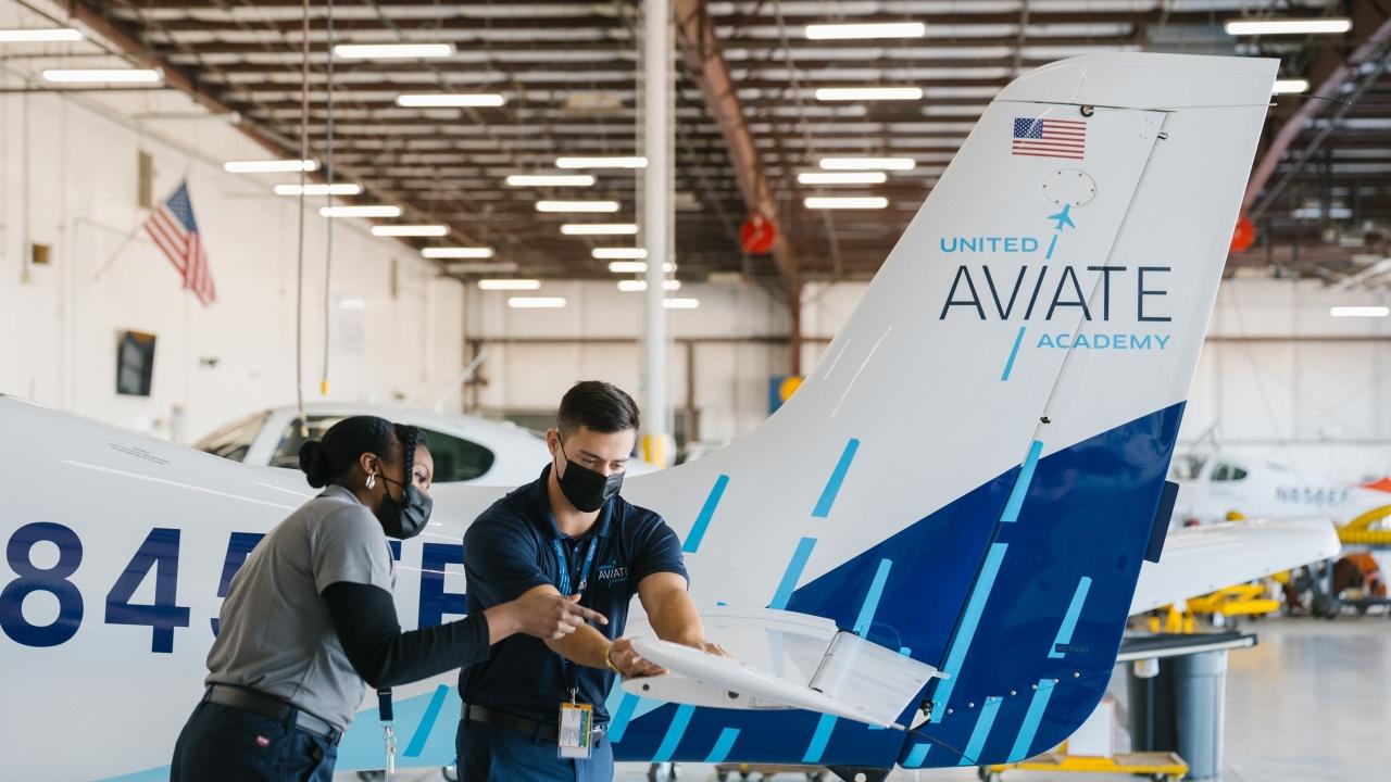 two people working in an airline hangar