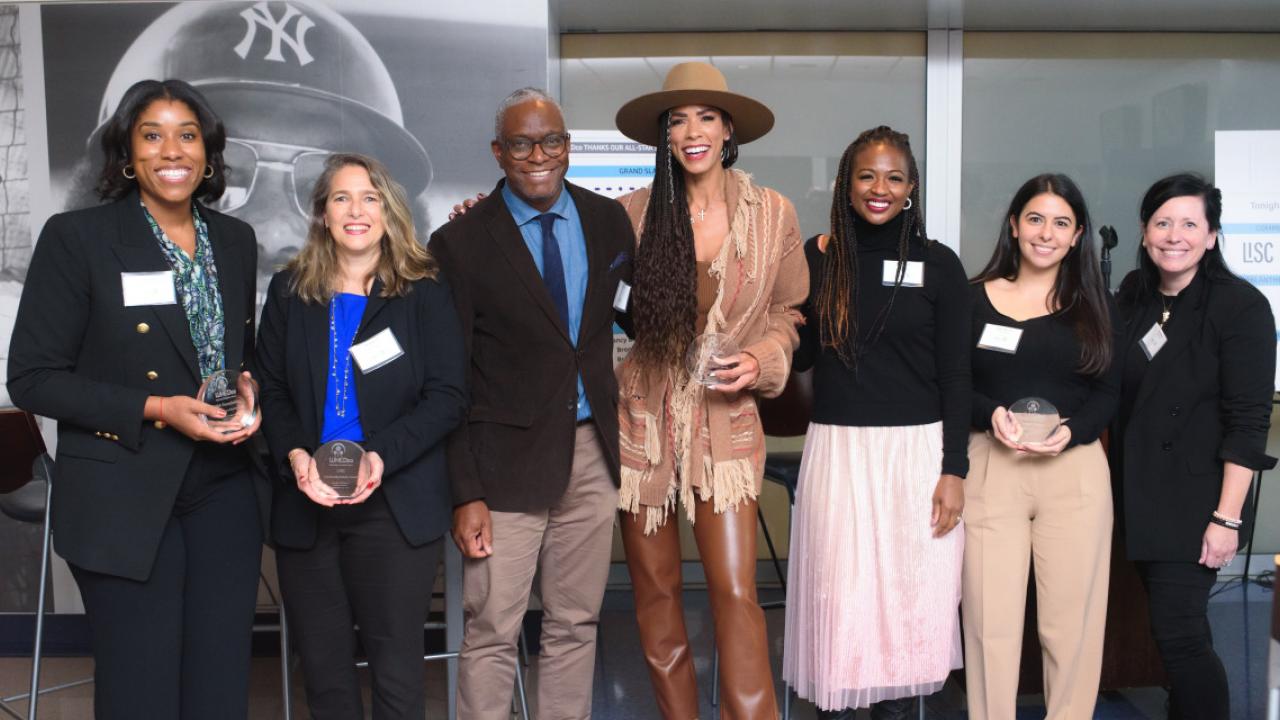 Group of people in a row, some holding awards