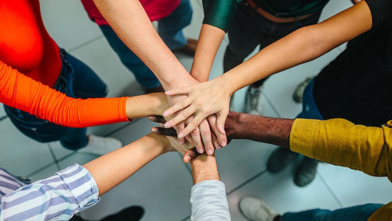Woman putting their hands together in a circle; like they are taking an oath.