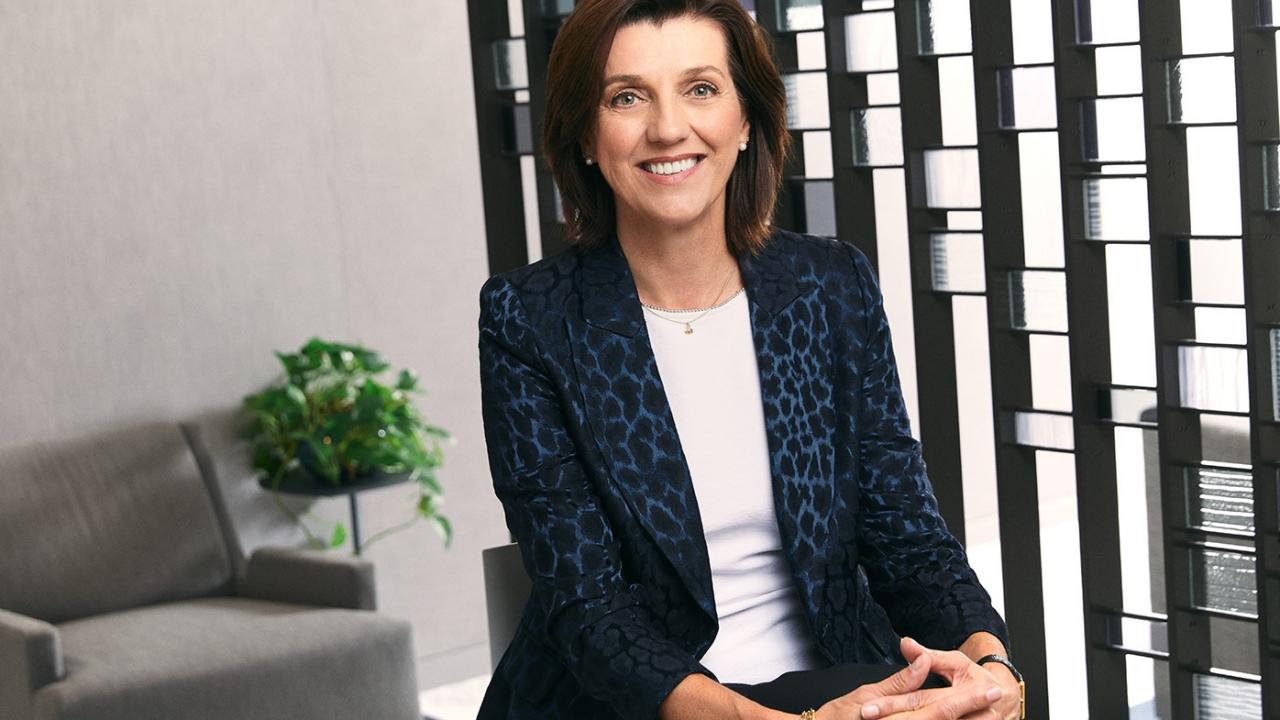Estelle Vester-Blokland, MD, sitting in an office, wearing a white shirt and blue jacket