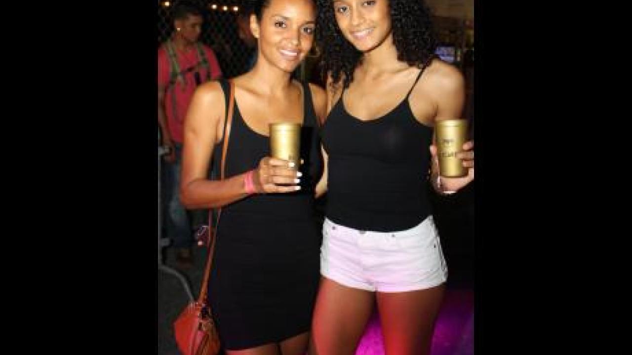 Former Miss Jamaica Sanya Hughes left and her sister Ysabelle, show off the Bacardi 'Green' Cups at the Major Lazer and Friends concert, recently held at the Mas Camp.