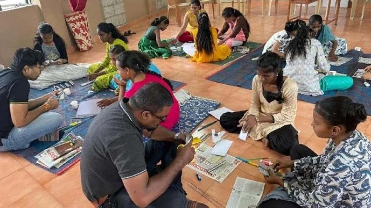 People sat on the floor painting 