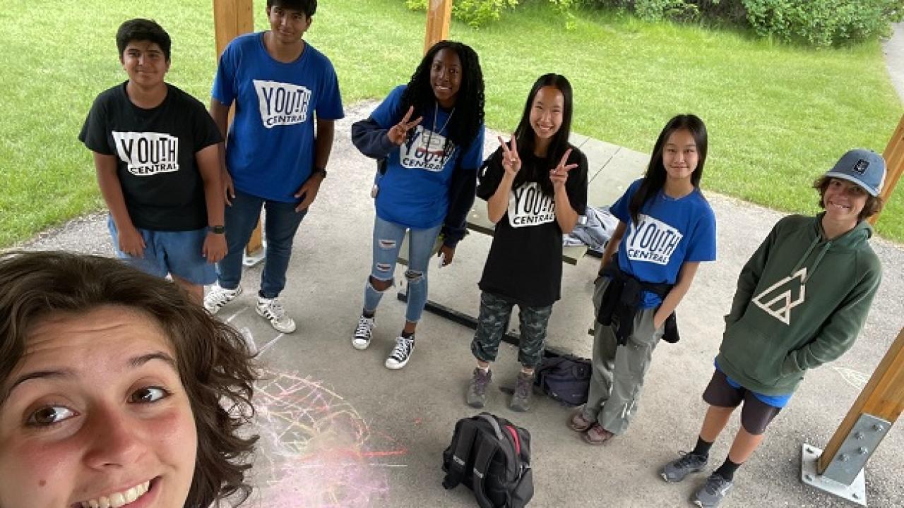 teens in Youth Central t-shirts and the photographer smiling in the foreground