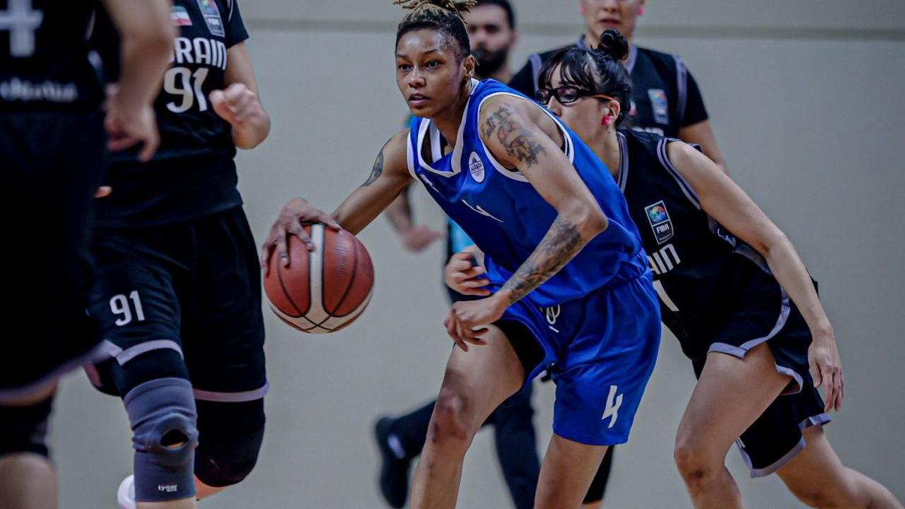 Ashanti Hunt wearing a blue jersey playing basketball 