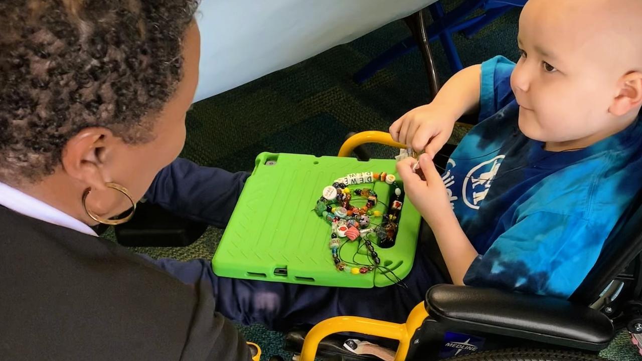 Aflac volunteers helping Dewey pick out even more beads to add to his collection.