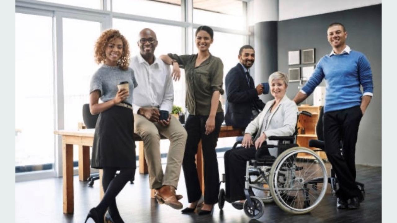 Group of employees seated, standing and in a wheelchair.