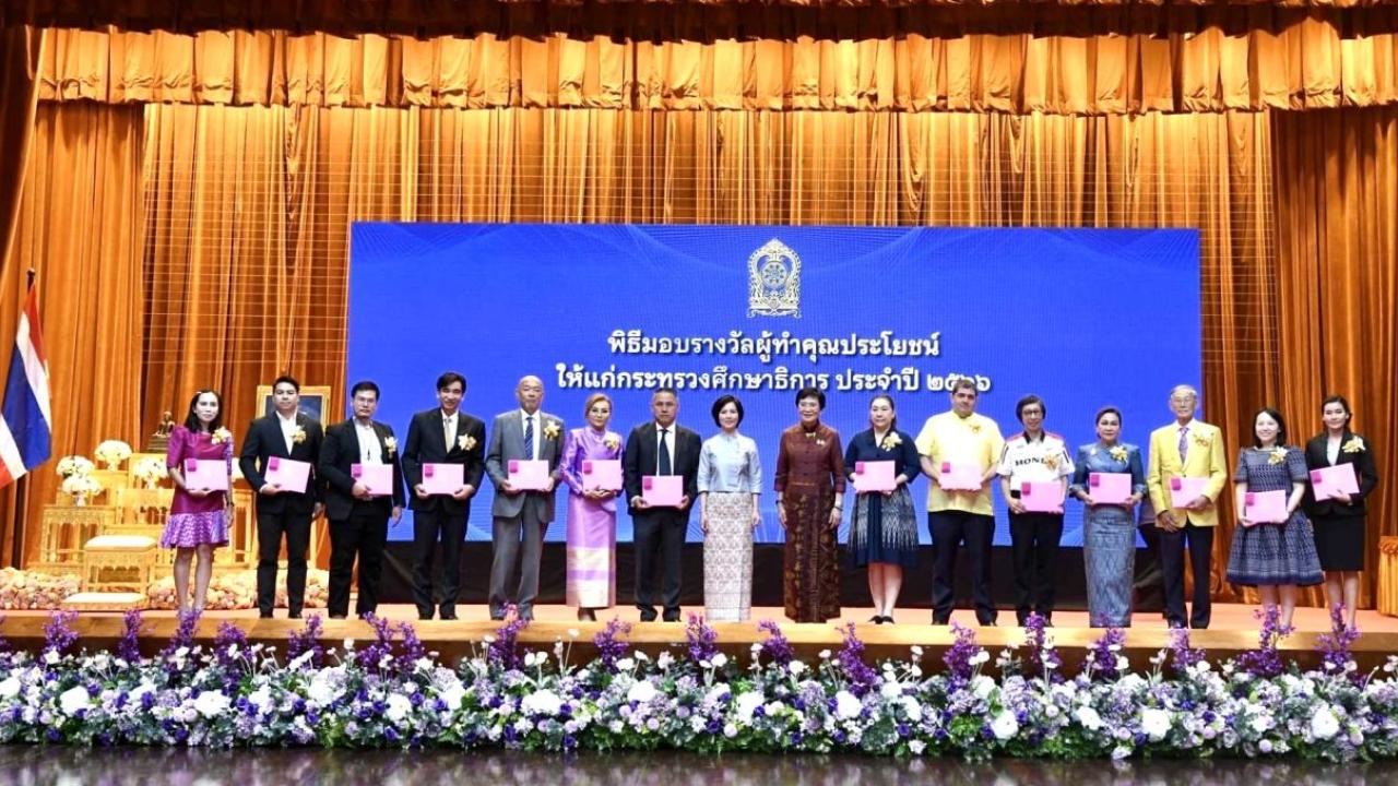 A line of people on a stage, holding certificates.
