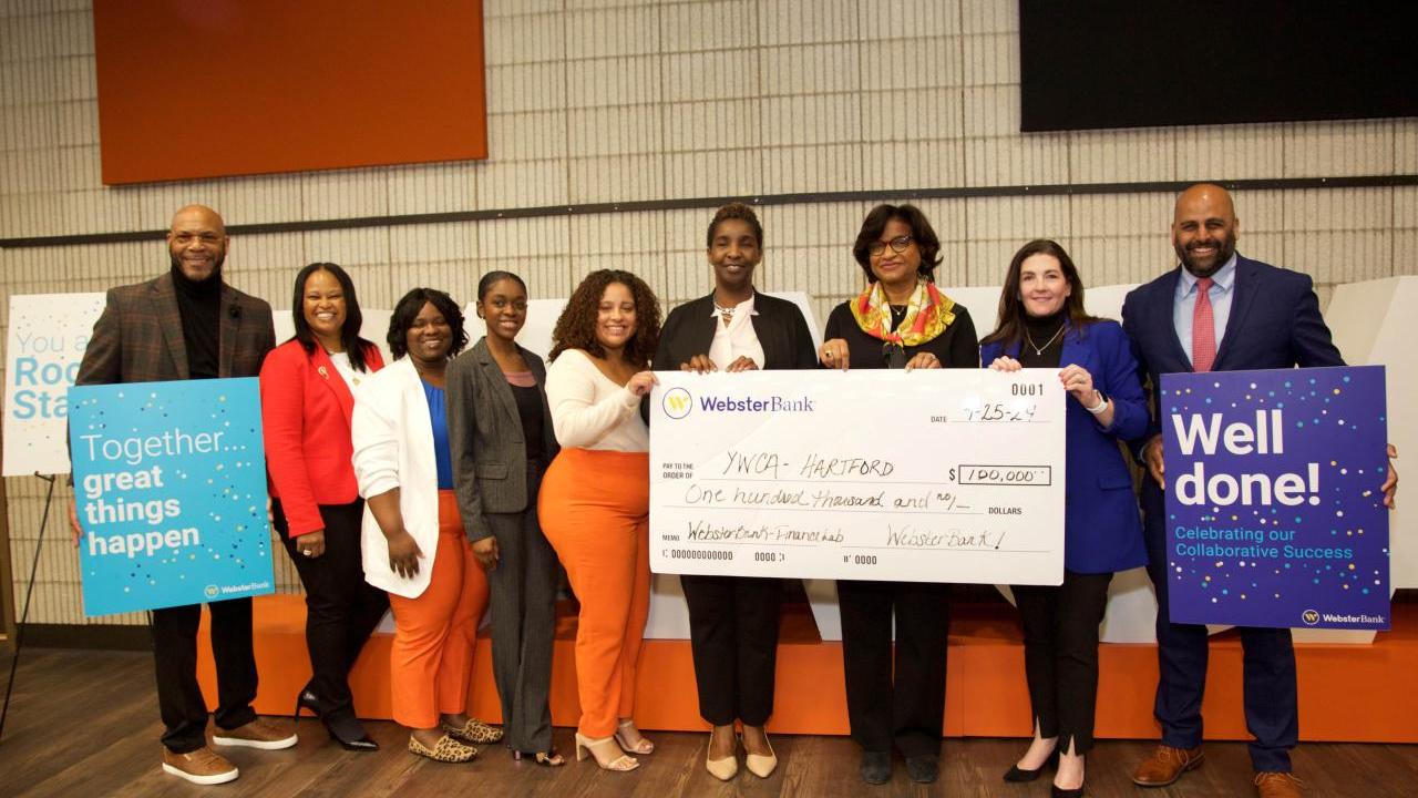 group standing with an oversized check