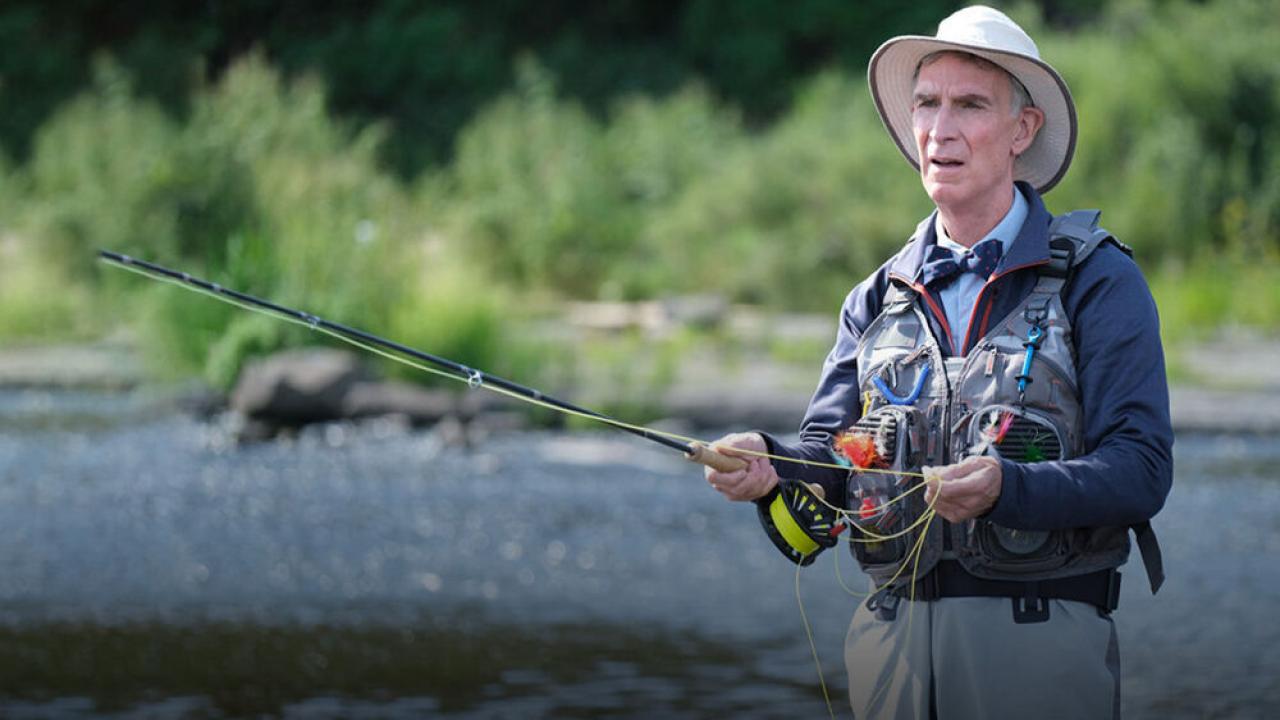 Bill Nye in a river fly fishing