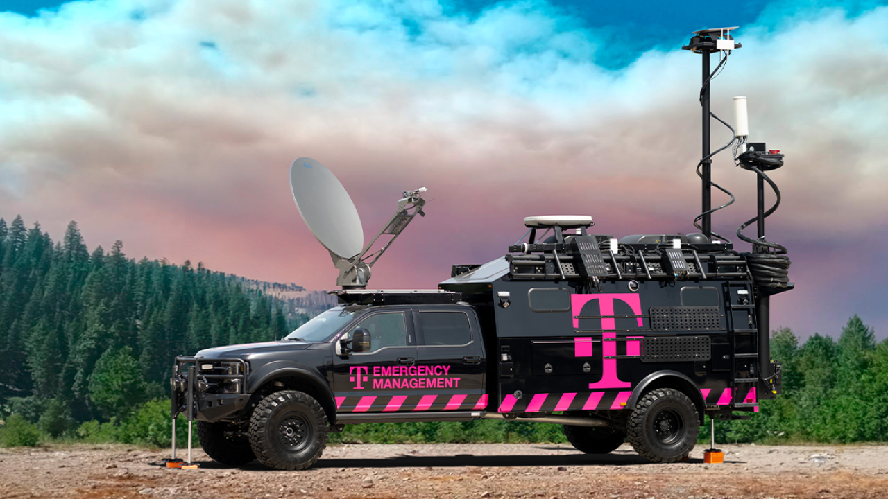 black and pink truck in front of trees and sky