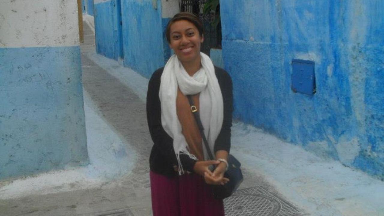 A person stood in the street smiling 