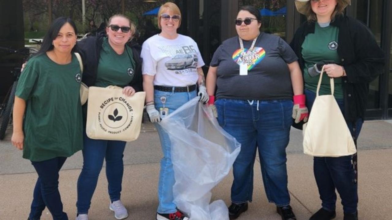 A group of people standing outside with trash bags