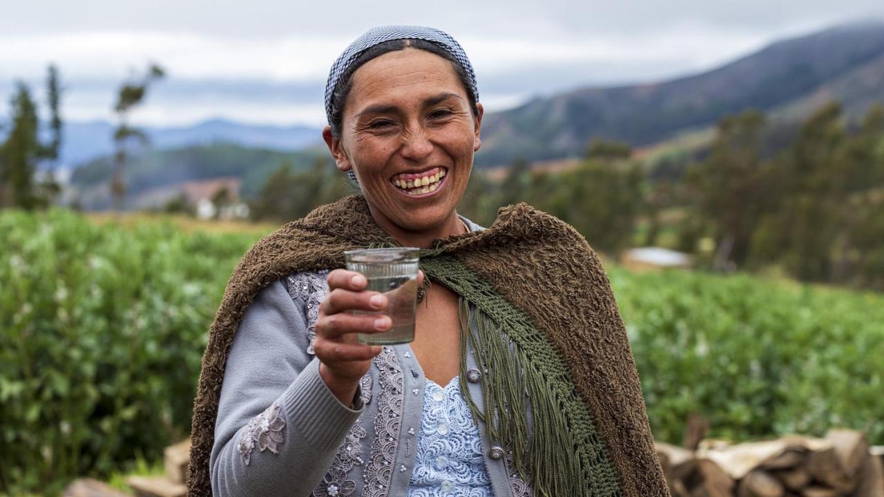 A Bolivian woman holds a glass of clean water from a new supply system installed by Water For People with funding from Kimberly-Clark.