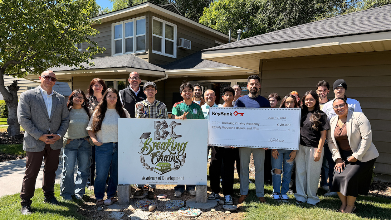 group of people holding celebratory check and banner