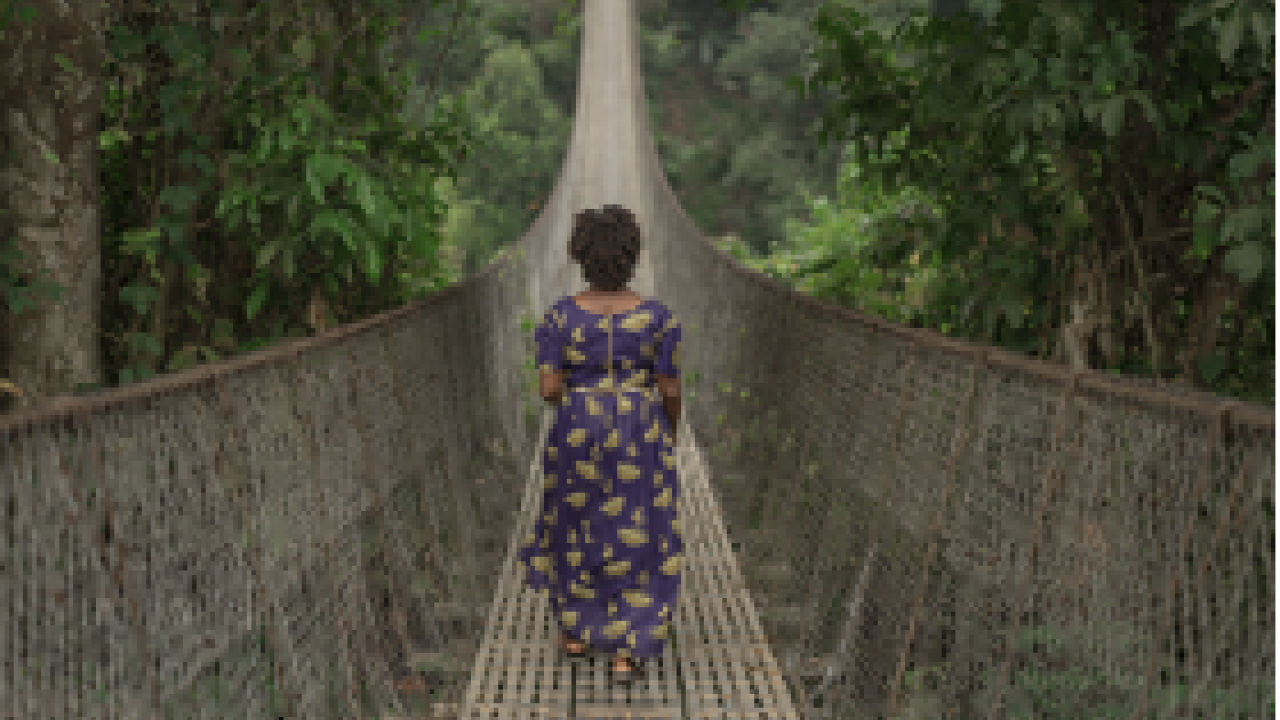 woman walking alone across a long bridge
