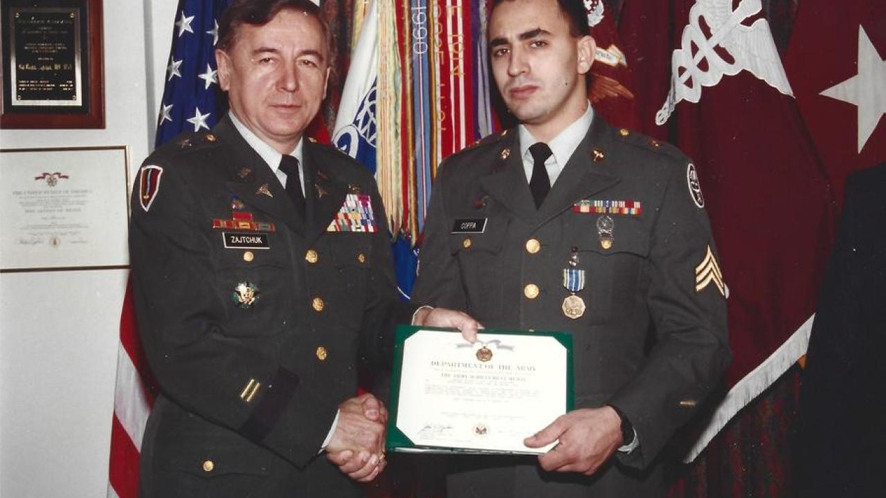 Jeff Coppa and another in military uniform as he receives an award.
