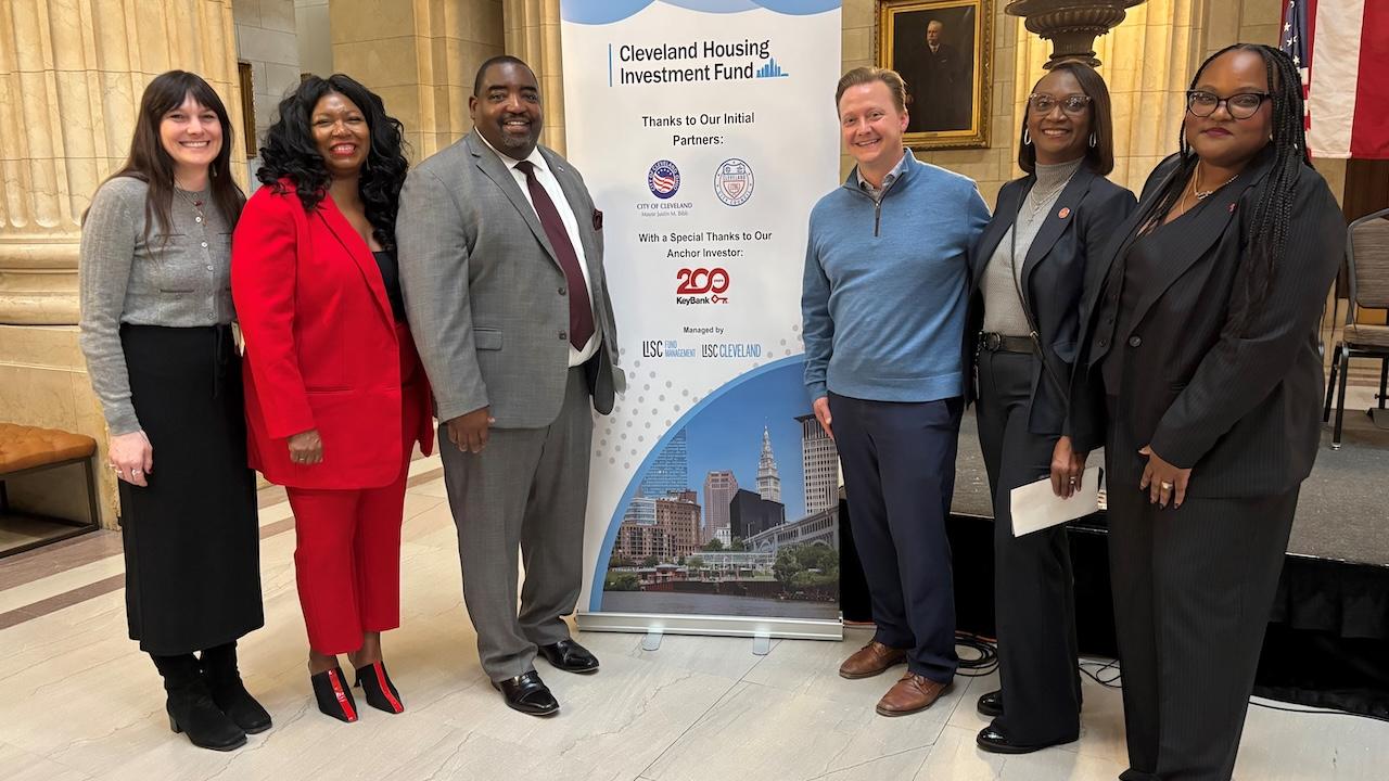 Representatives from the City of Cleveland and KeyBank shown in front of the Cleveland Housing banner.