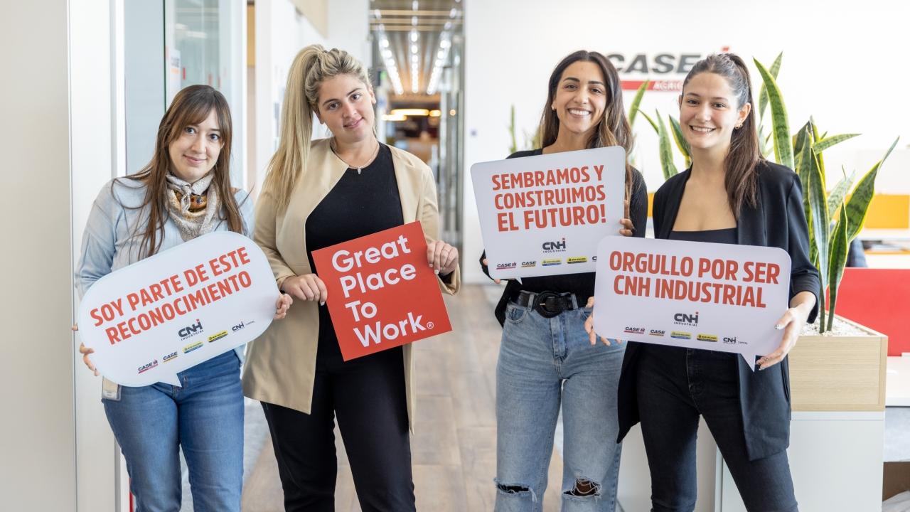 4 people holding signs celebrating Great Place to Work certification