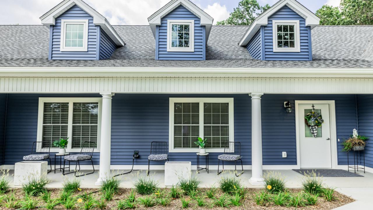 The exterior of a blue house is shown.