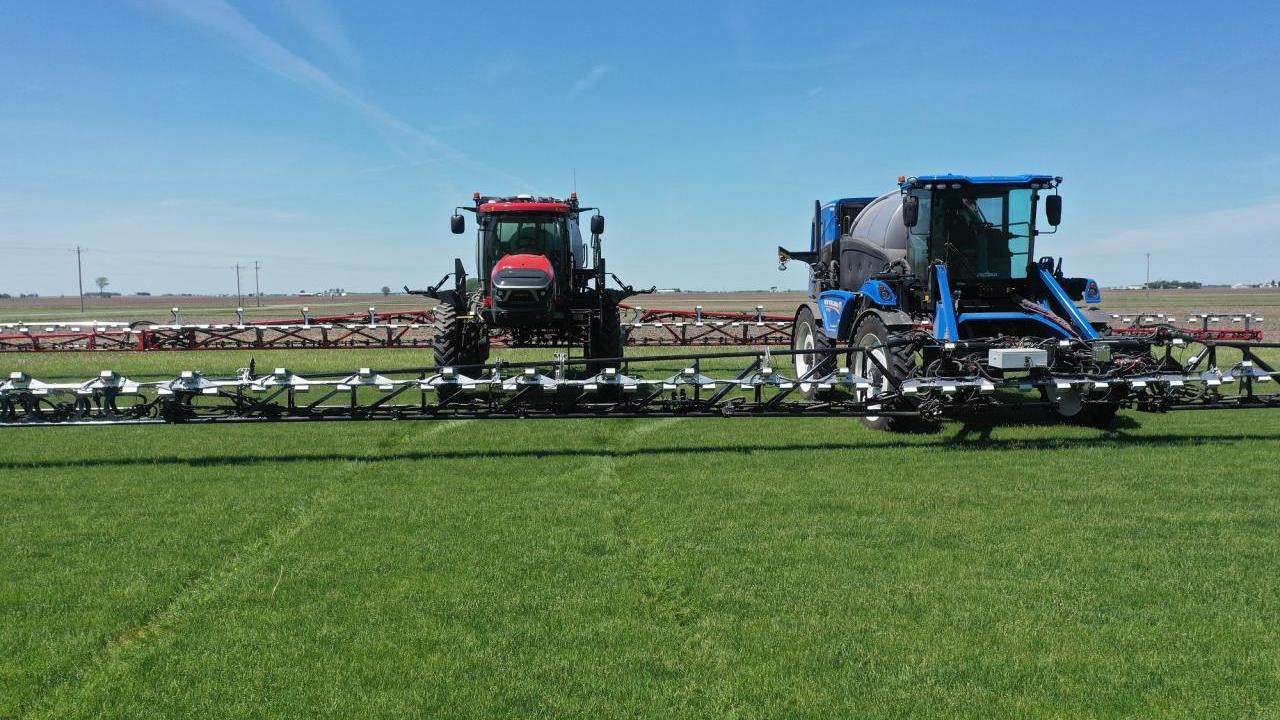 Two tractors spraying fields