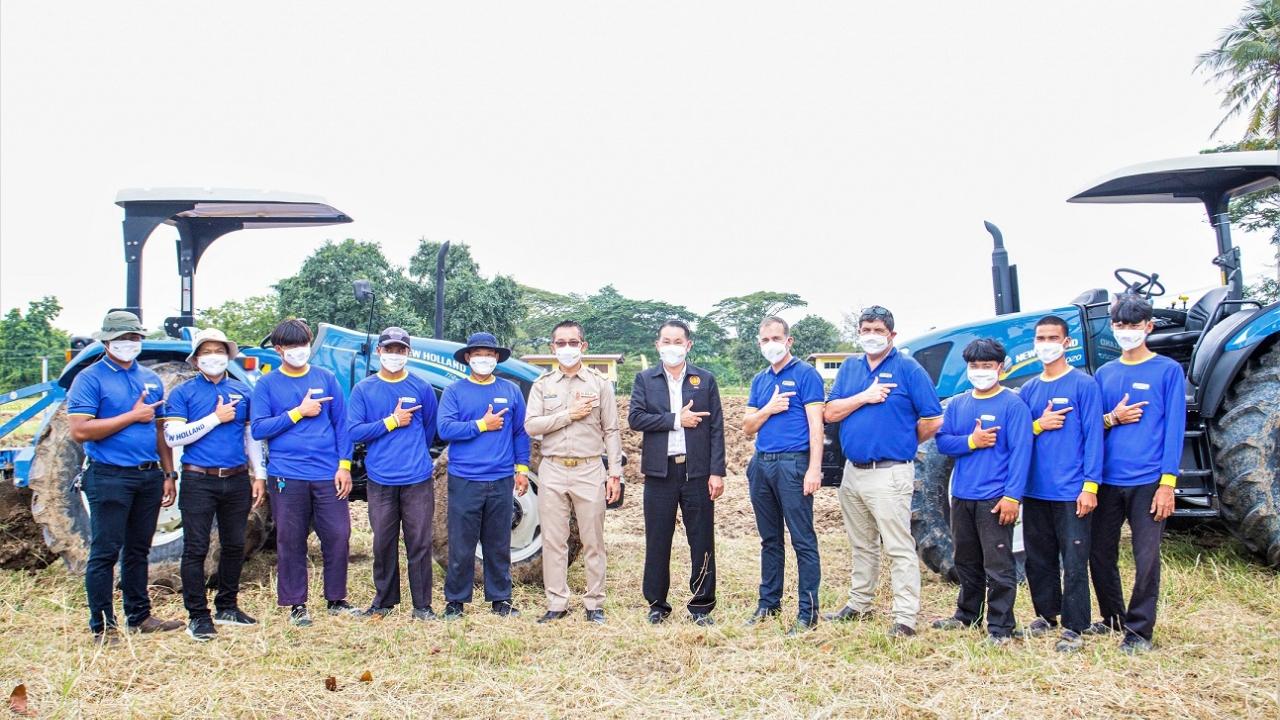 Group of people posing in front of two tractors
