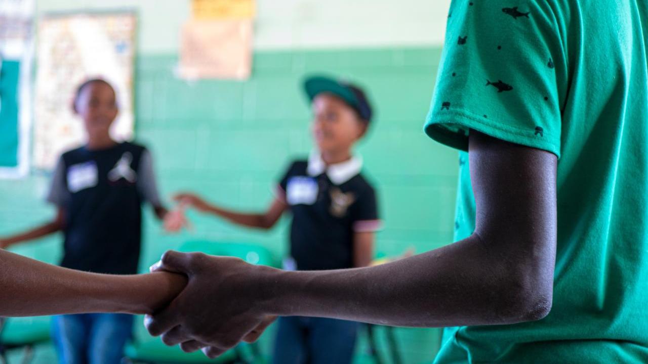 students holding hands in a circle
